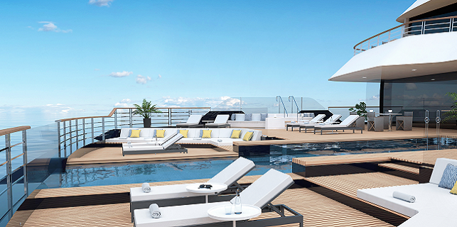 Resort pool deck with white loungers and teak decking overlooking a calm blue ocean